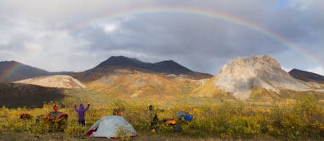 A camper enjoys views of a rainbow.