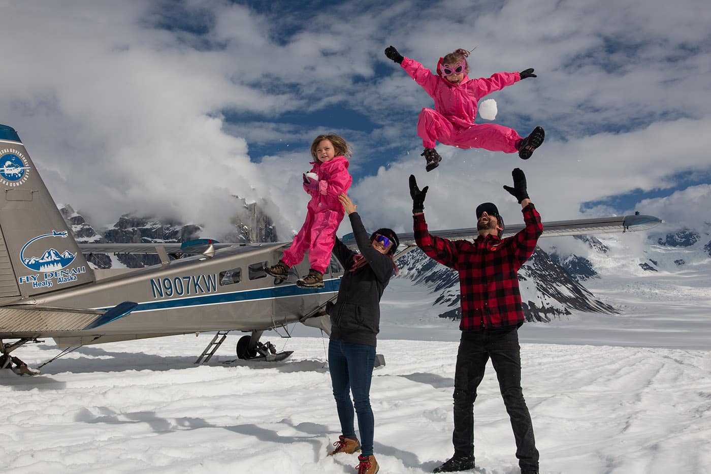 parents playing with kids in a snowy landscape