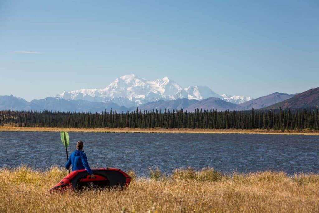 man with kayak next to the water